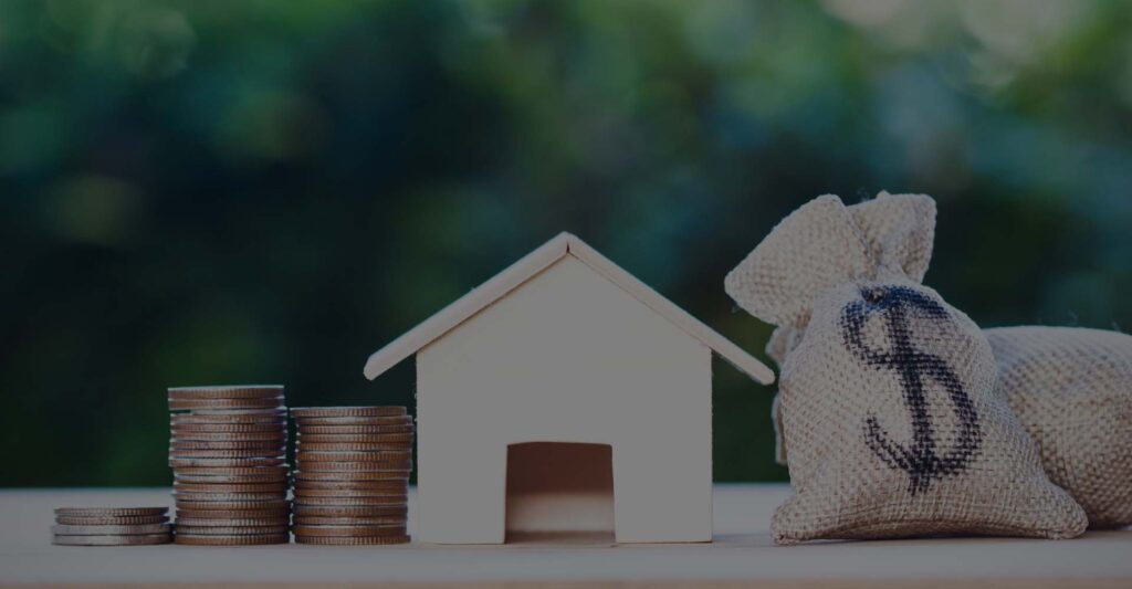 a small wooden house with money bags next to it