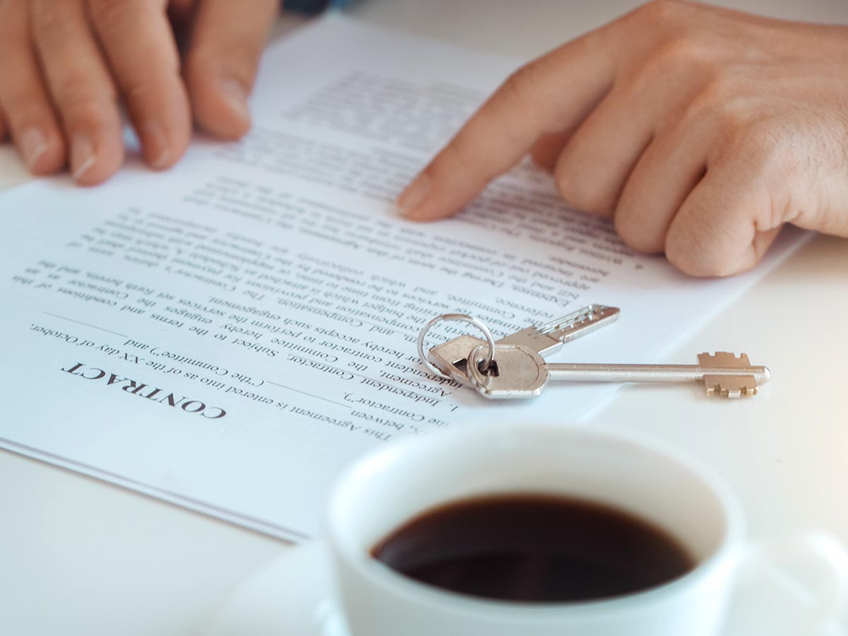 Person looking over home loan contract while drinking coffee