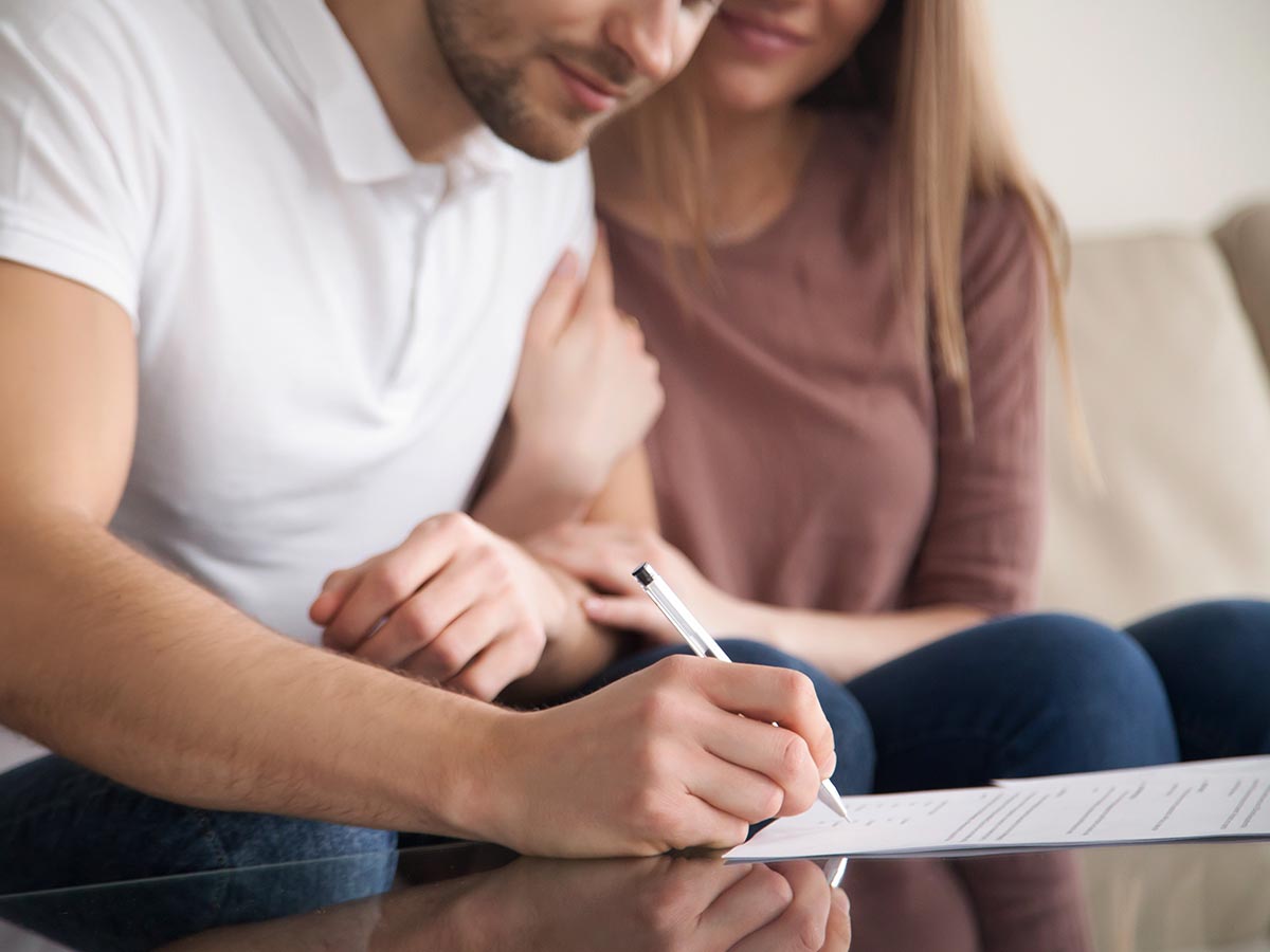 Couple sigining home loan contract