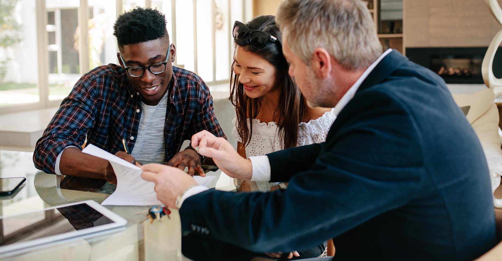 Couple going over home loan contract with a mortgage team member