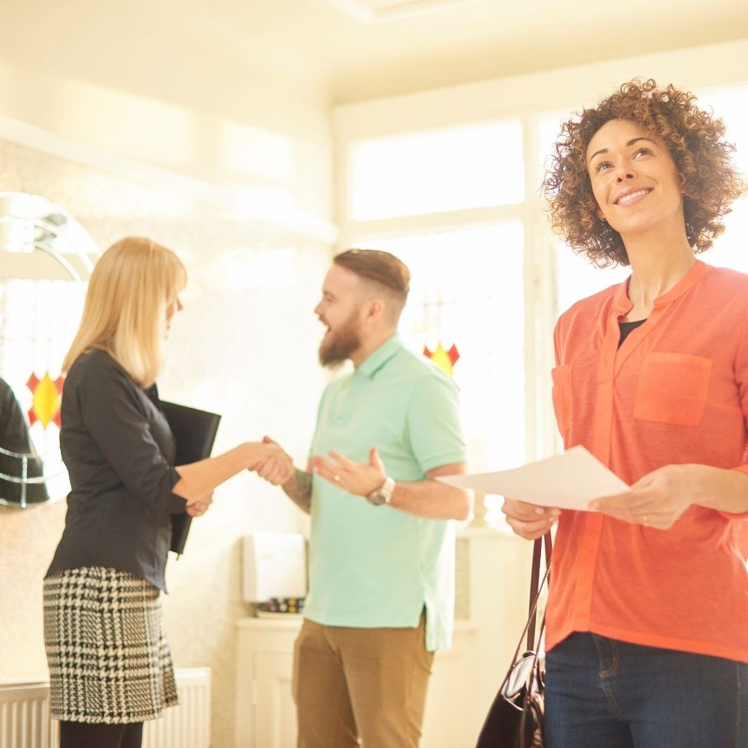 Real estate agent showing a couple a house