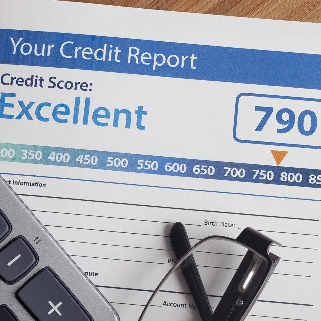 Document showing credit score with a calculator and a pair of glasses