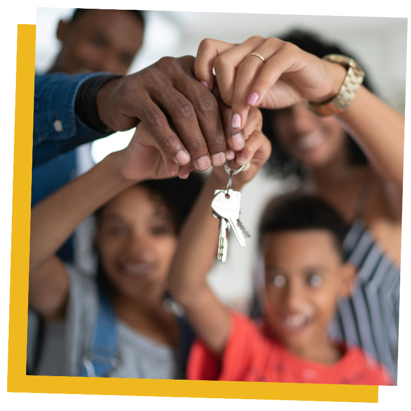 A family of four holding keys to their new home