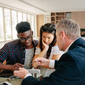 Three people discussing housing paperwork