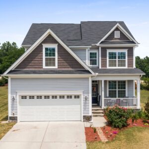 exterior of 2 story house with 2 car garage, porch, and brown siding 